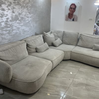 ספה אפורה גדולה בחדר מגורים עם תמונה על הקיר