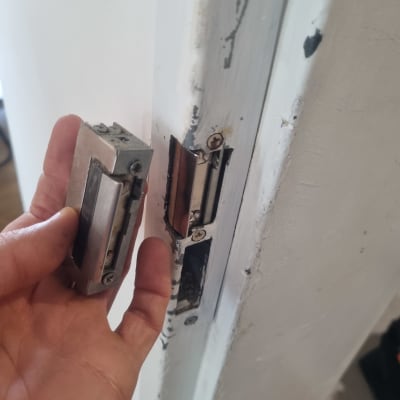 יד מחזיקה מנעול דלת מתכת ליד משקוף