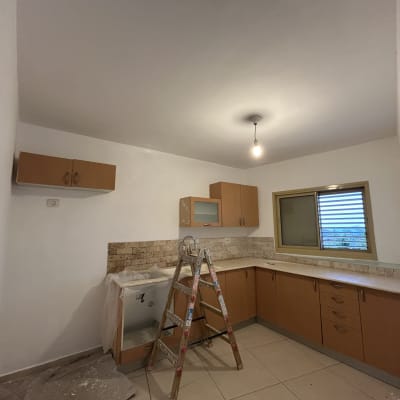 סולם בחדר עם קירות צבועים ולוח גבס