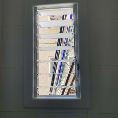 חלון עם תריסי אלומיניום פתוחים חלקית