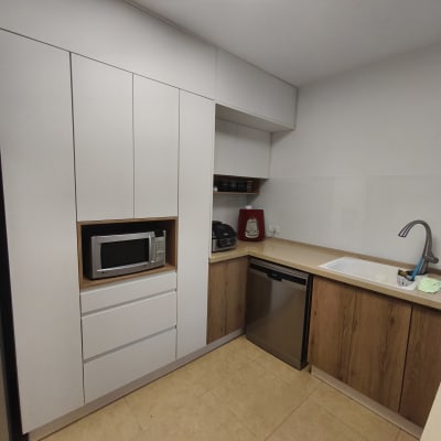 מטבח מודרני עם ארונות לבנים ומכשירי חשמל