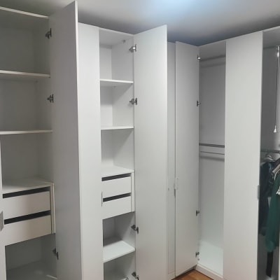 ארון בגדים לבן עם דלתות פתוחות ומדפים פנימיים