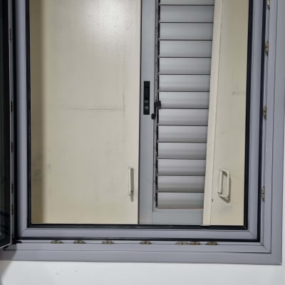 חלון עם מסגרת מתכת ותריסים סגורים