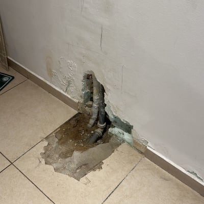 צינורות חשופים בקיר עם טיח מתקלף