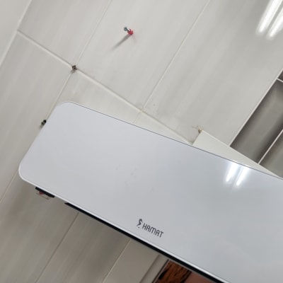 מכשיר חשמלי מותקן על קיר אריחים לבנים