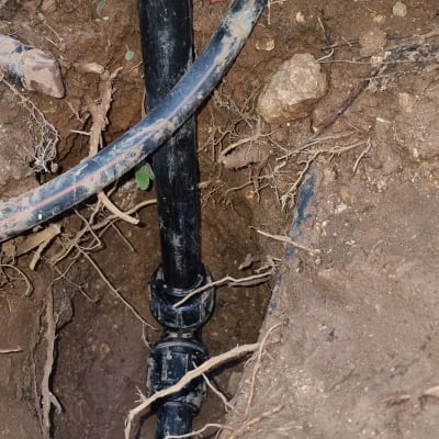 צינור שחור באדמה עם חיבורים