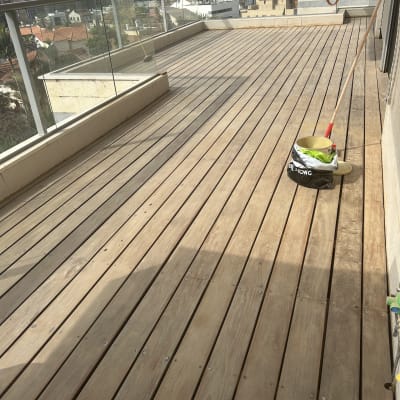 מרפסת עץ עם דלי ומטאטא על הרצפה