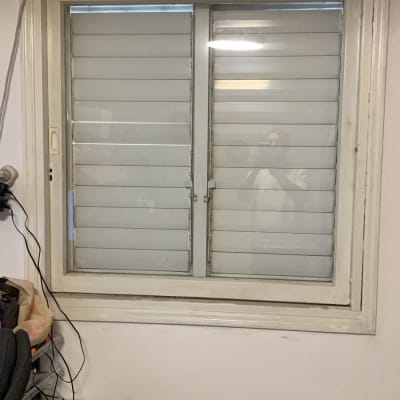 חלון עם תריסים סגורים ומכשיר מיזוג אוויר