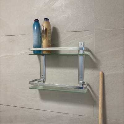 מדף זכוכית עם בקבוקים בחדר אמבטיה