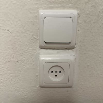 שקע חשמל ומתג על קיר לבן