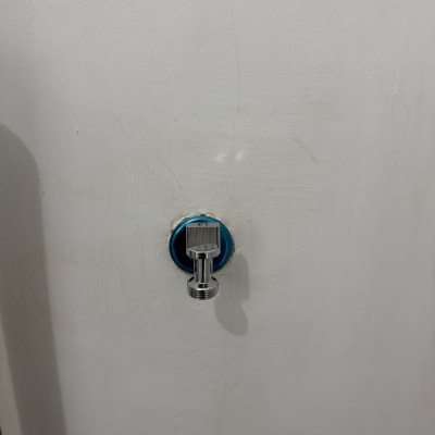 ברז מים מותקן על קיר לבן