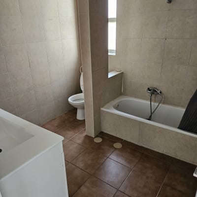 חדר אמבטיה נקי עם אמבטיה, כיור ושירותים