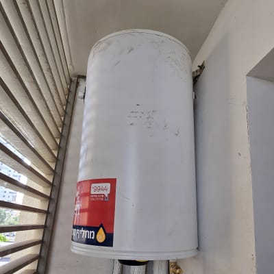 דוד שמש מותקן על קיר עם צינורות מחוברים