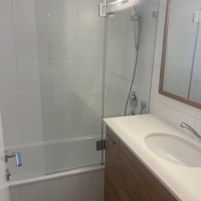 חדר אמבטיה נקי עם מקלחון וכיור