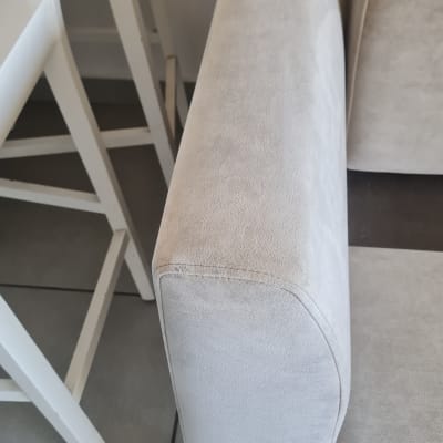 ספה בצבע בהיר ליד כיסאות לבנים