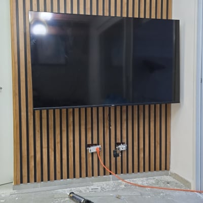 טלוויזיה מותקנת על קיר עץ, כלים על הרצפה