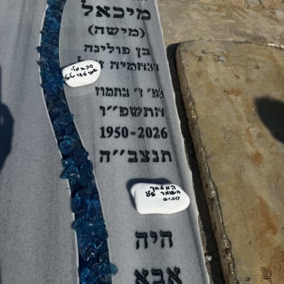 מצבה עם כיתוב ואבנים כחולות