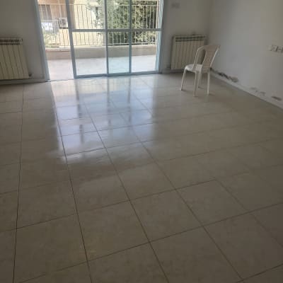 רצפה נקייה ומבריקה עם כיסא פלסטיק בחדר ריק.