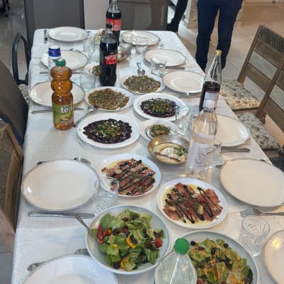 שולחן ערוך עם מנות שף מגוונות ואנשים במטבח