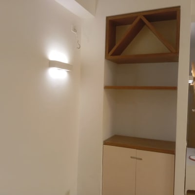 ארון קיר עם מדפים ותאורה על קיר צבוע