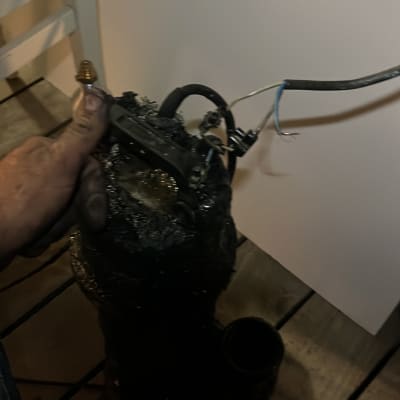 יד מחזיקה משאבה עם חוטים חשמליים חשופים