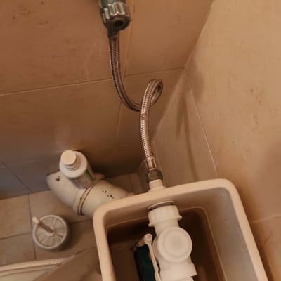 צינור מתכת מחובר למיכל שירותים