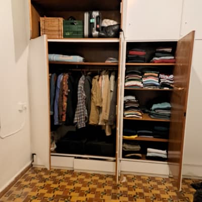 ארון בגדים פתוח עם בגדים מקופלים ותלויים