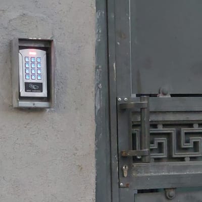 לוח מקשים מואר על קיר ליד שער מתכת