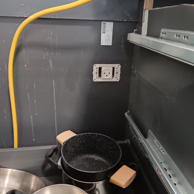 שקע חשמל עם כבל צהוב וכלי מטבח