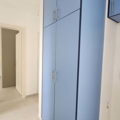 ארון כחול עם דלתות וידיות מתכת בחדר ריק