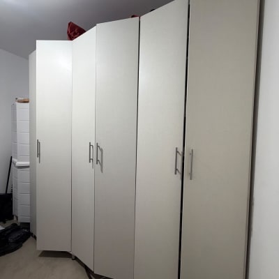 ארון בגדים גדול ובהיר בעל מספר דלתות המורכב בחדר