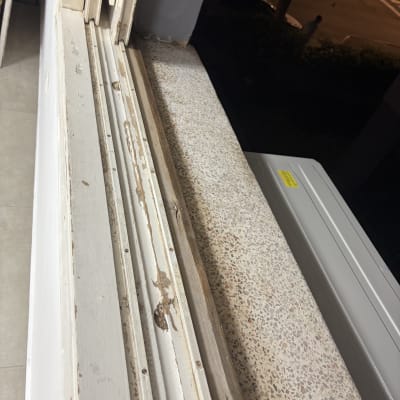 חלון עם מסגרת עץ מתקלפת ונזקי צבע