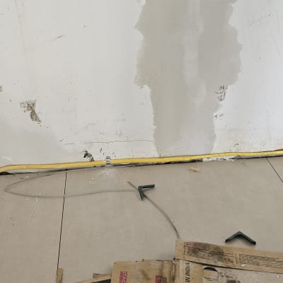 צינור גז צהוב על קיר לבן עם רצפת בטון