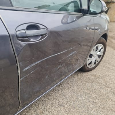 שריטות על דלת רכב אפורה