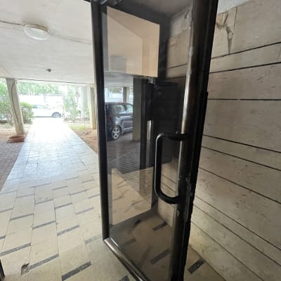 דלת זכוכית עם מסגרת מתכת וידית שחורה