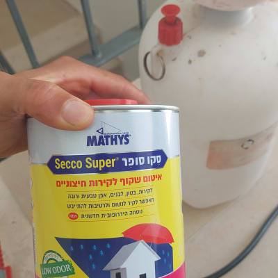 יד מחזיקה פחית איטום שקוף לקירות חיצוניים