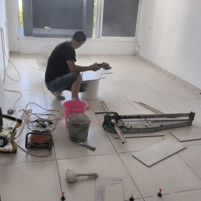 עובד עם כלי עבודה על רצפה בתהליך שיפוץ