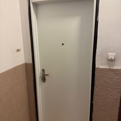 דלת לבנה עם ידית מתכת במסדרון