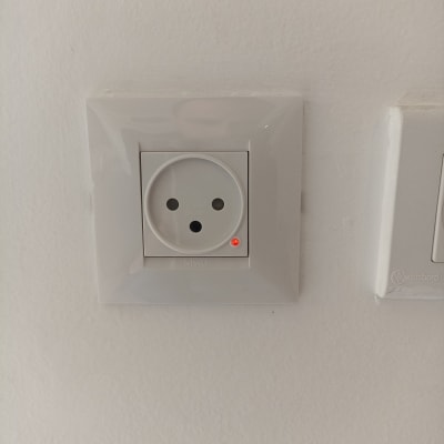 שקע חשמל עם נורית חיווי על קיר לבן