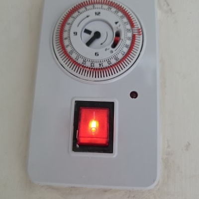 טיימר עם מתג אדום על קיר לבן