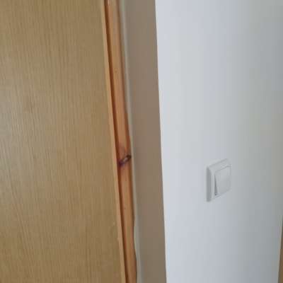 קיר גבס עם מתג חשמל ודלת עץ