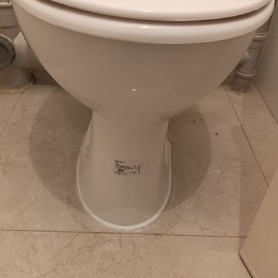 אסלה לבנה עם מכסה סגור וצינור חיבור