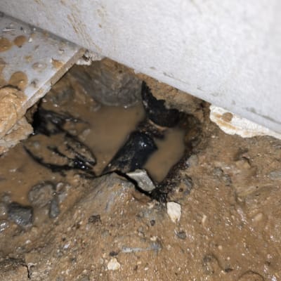 נזילה בצינור מתחת לרצפה עם מים ובוץ