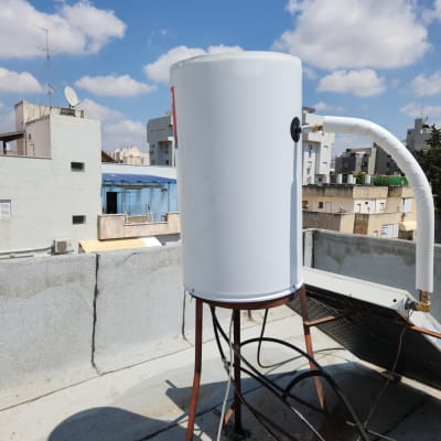 דוד שמש לבן על גג עם צינור מחובר