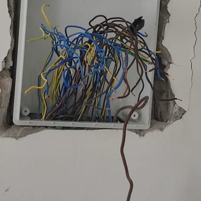 קופסת חשמל פתוחה עם חוטים צבעוניים חשופים