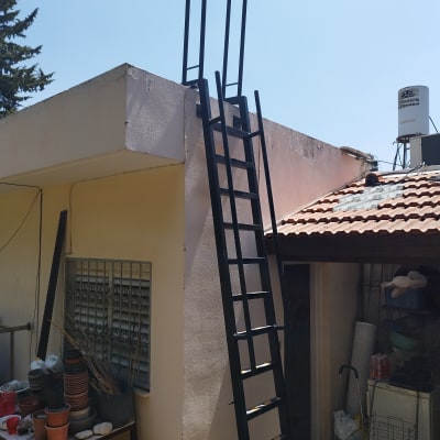 סולם מתכת שחור על גג מבנה