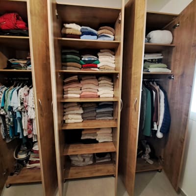 ארון בגדים עם מדפים מסודרים וסוודרים מקופלים