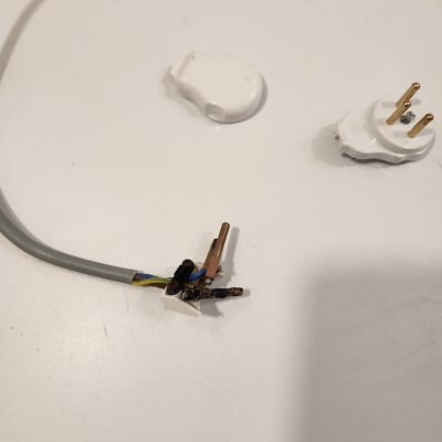 חוט חשמל חשוף עם תקע מפורק על שולחן לבן