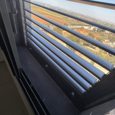 נוף מחלון עם תריסים פתוחים ונוף עירוני