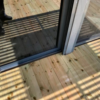 רצפת עץ עם צללים ליד דלת זכוכית